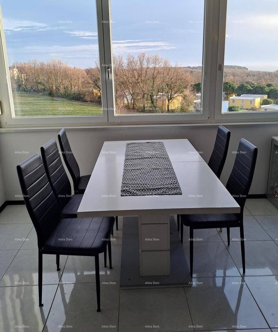 Heller Essbereich mit modernem Tisch und Stühlen, großen Fenstern und Blick auf die Landschaft.