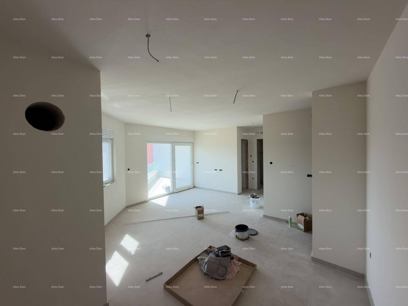Geräumiger Wohnbereich im Rohbau mit Fliesenboden und viel Tageslicht durch die Fenster.