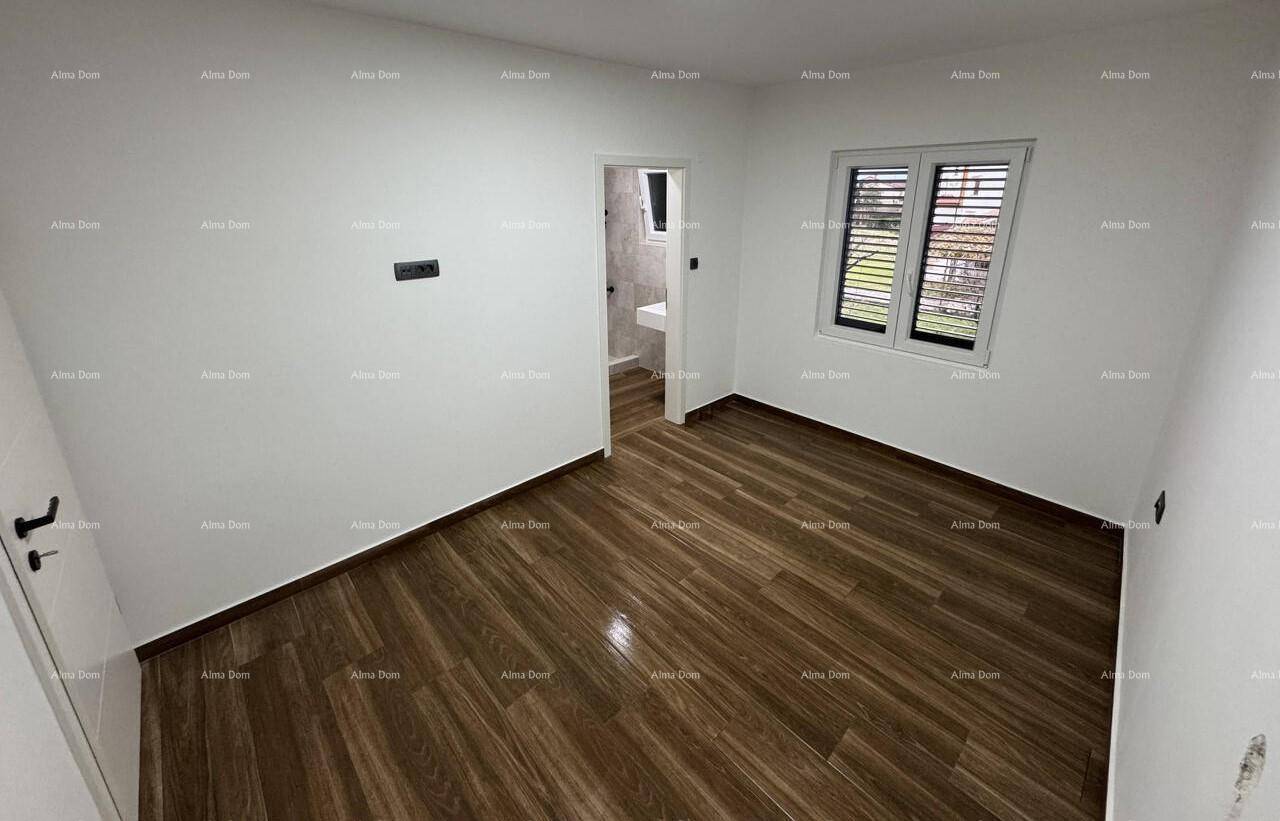 Helles, leeres Schlafzimmer mit modernem Holzboden und Fenster.