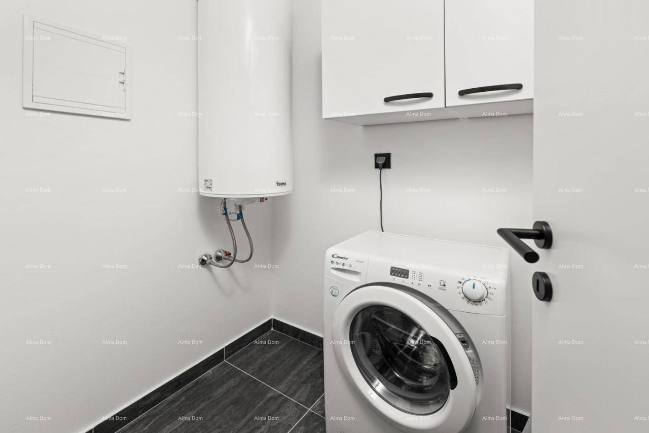 Praktischer Hauswirtschaftsraum mit Waschmaschine, Warmwasserbereiter und Hängeschränken für zusätzlichen Stauraum.