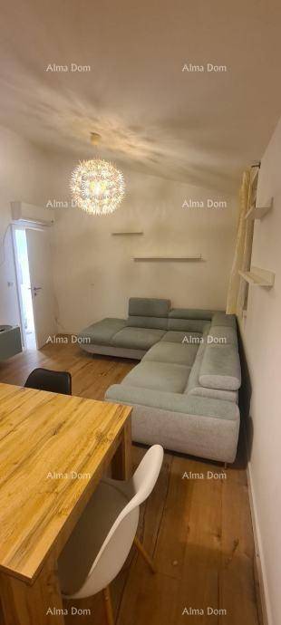 Detailansicht des Wohnzimmers mit bequemer Couch und Holztisch unter schräger Decke.