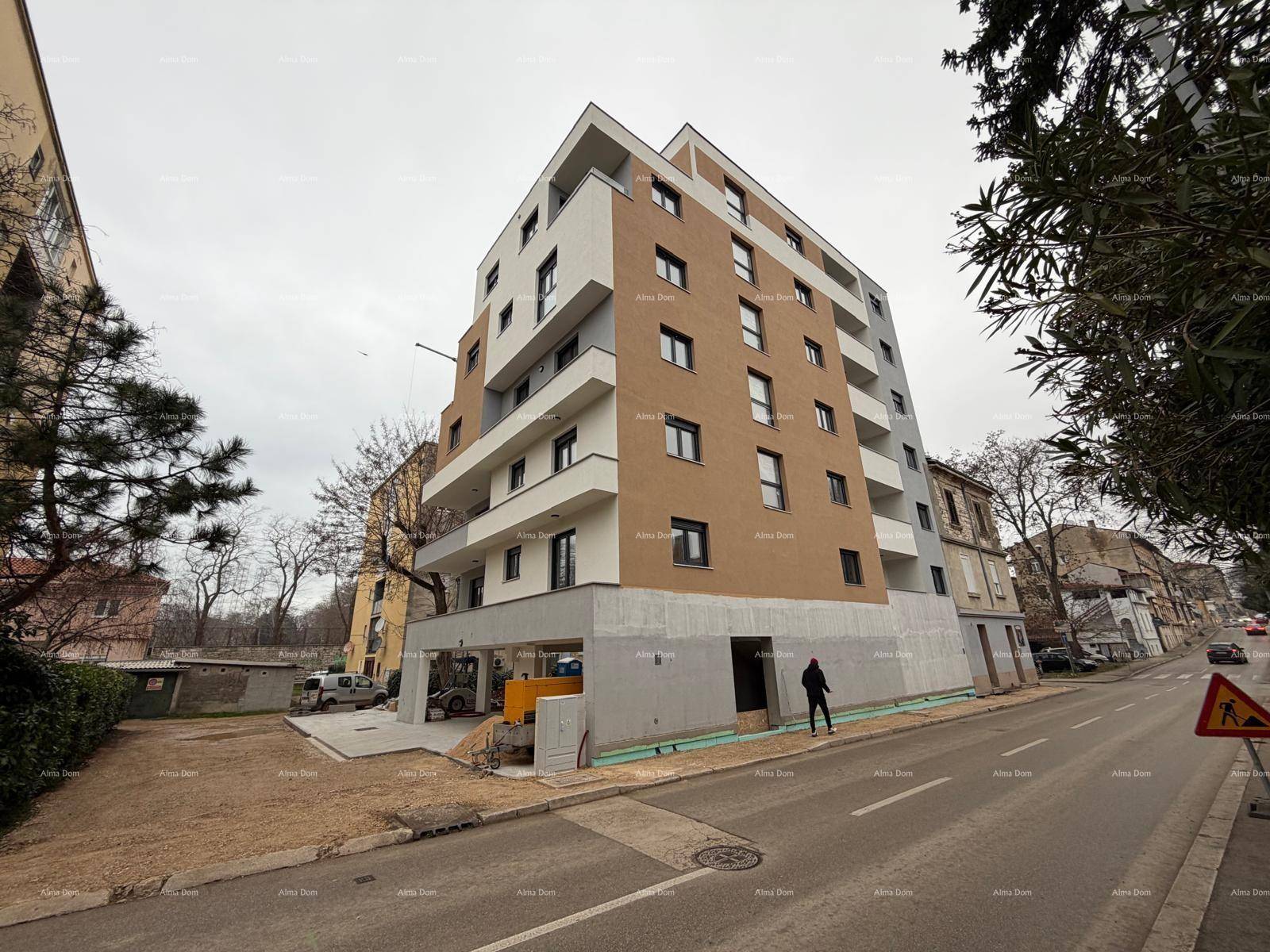Modernes Wohngebäude mit mehrfarbiger Fassade und Baustelle im Erdgeschoss.