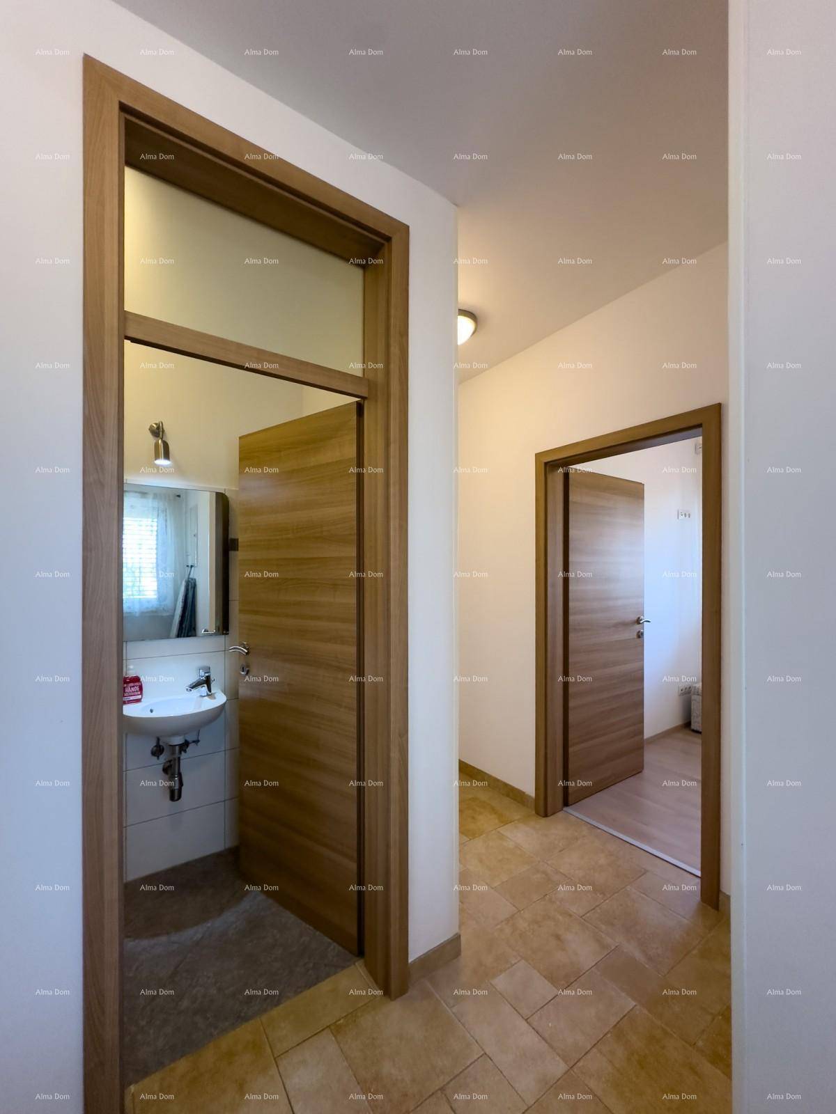 Heller Flur mit Holztüren und Blick in ein Badezimmer sowie weitere Zimmer.