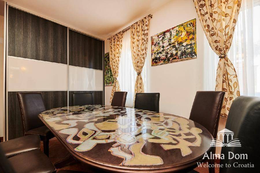 Eleganter Essbereich mit großem Holztisch und bequemen Stühlen, ideal für Familienessen.