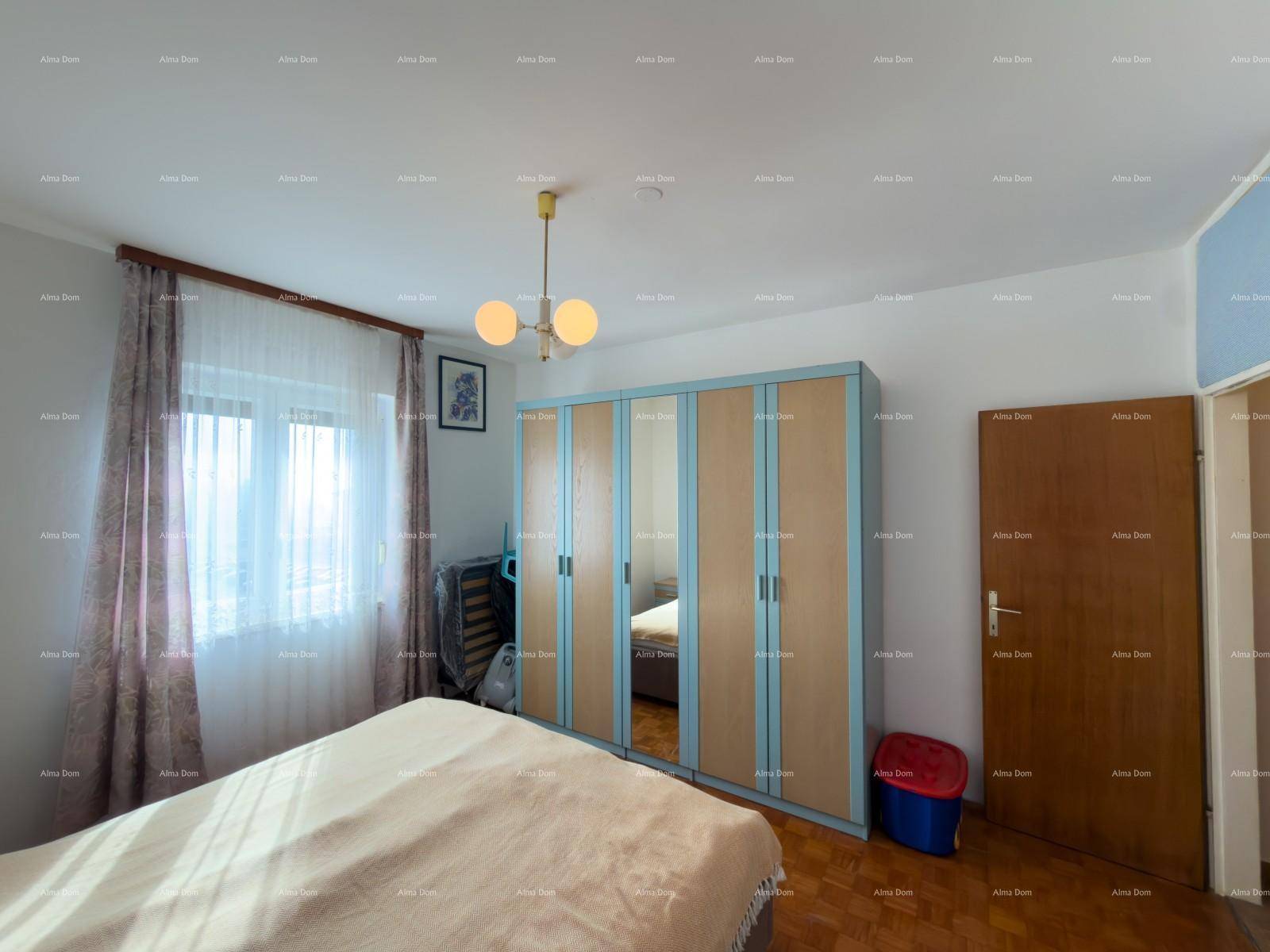 Schlafzimmer mit Doppelbett, Parkettboden und großem Kleiderschrank.