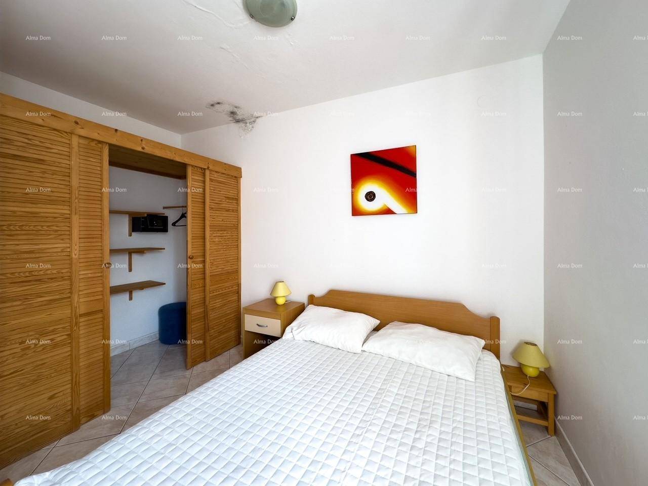 Schlafzimmer mit Doppelbett, Holzschranktüren und einem farbigen Kunstwerk an der Wand.