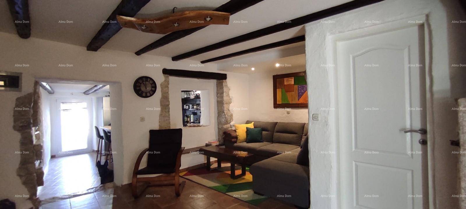 Gemütliches Wohnzimmer mit großem Ecksofa, Couchtisch und farbenfrohem Teppich unter Holzbalken.