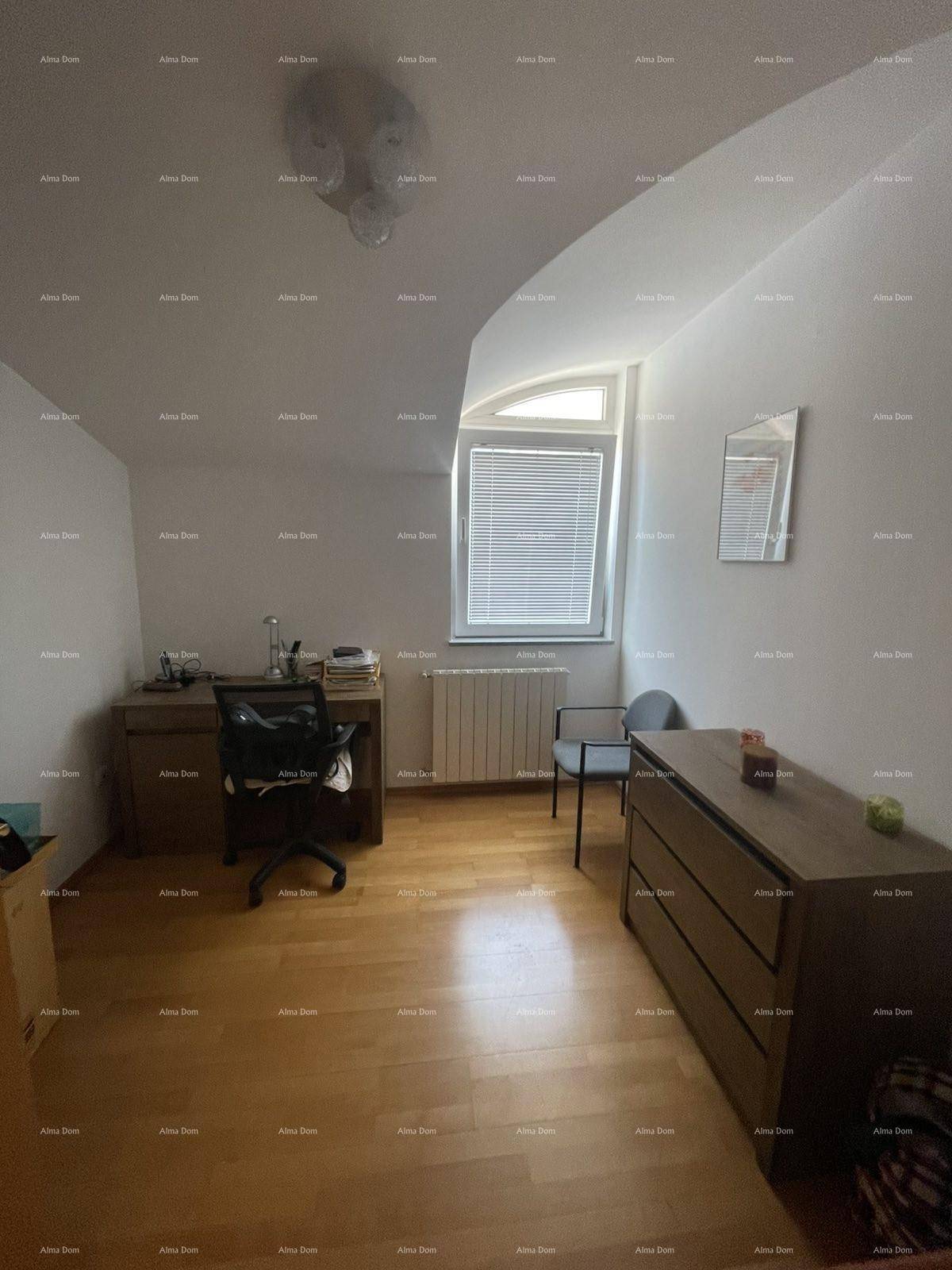 Ruhiges Arbeitszimmer mit Holzboden, Schreibtisch und Fenster mit viel Tageslicht.