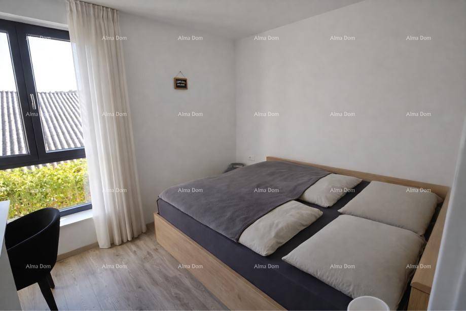 Helles Schlafzimmer mit Doppelbett, Holzbettrahmen und großem Fenster, das viel Tageslicht hereinlässt.