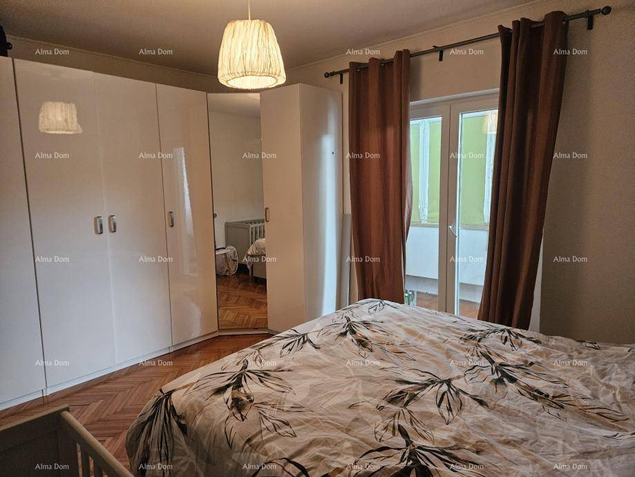 Schlafzimmer mit großem Kleiderschrank, Doppelbett und Zugang zu einem Außenbereich.