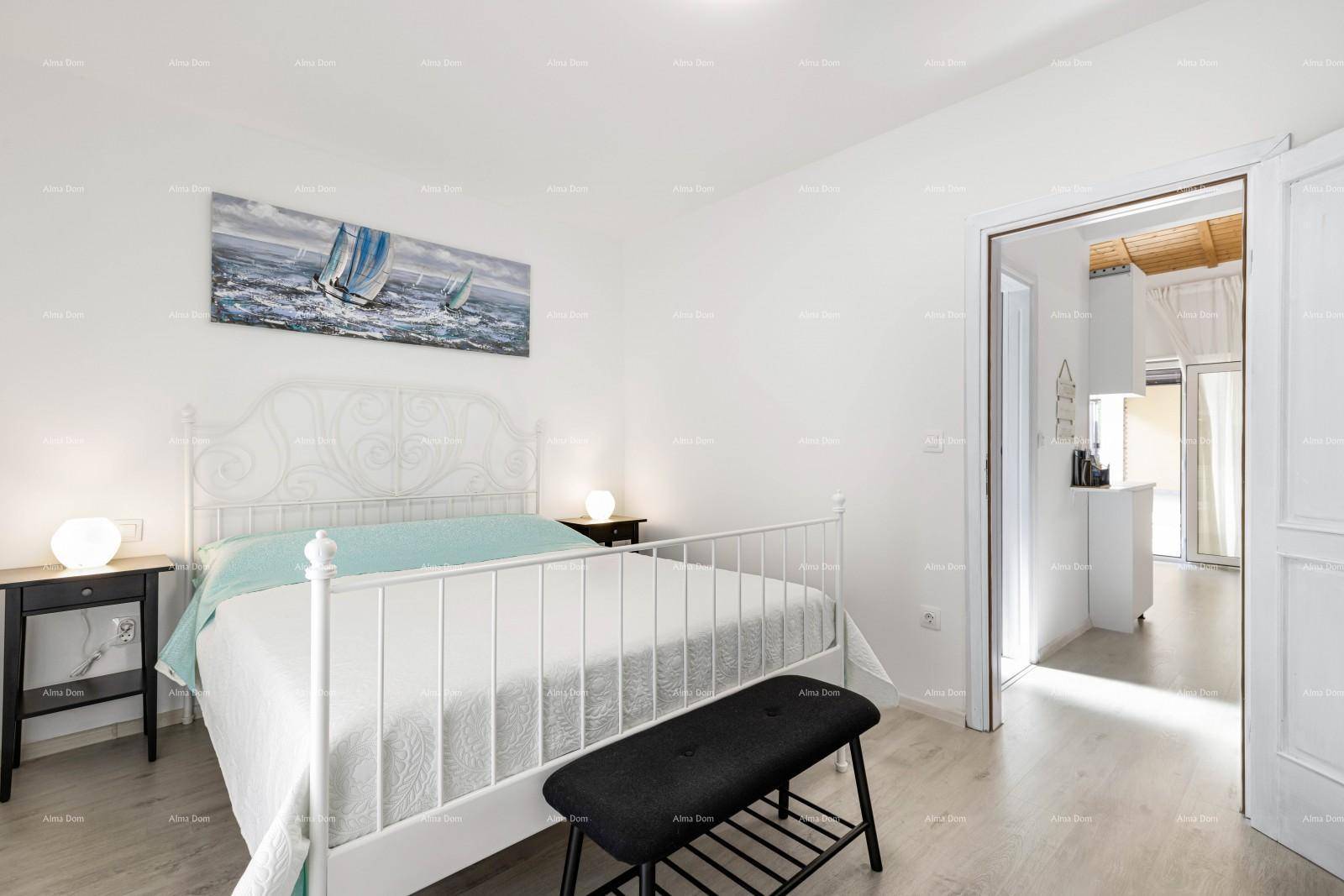 Helles Schlafzimmer mit weißem Metallbett und Blick auf den angrenzenden Raum.