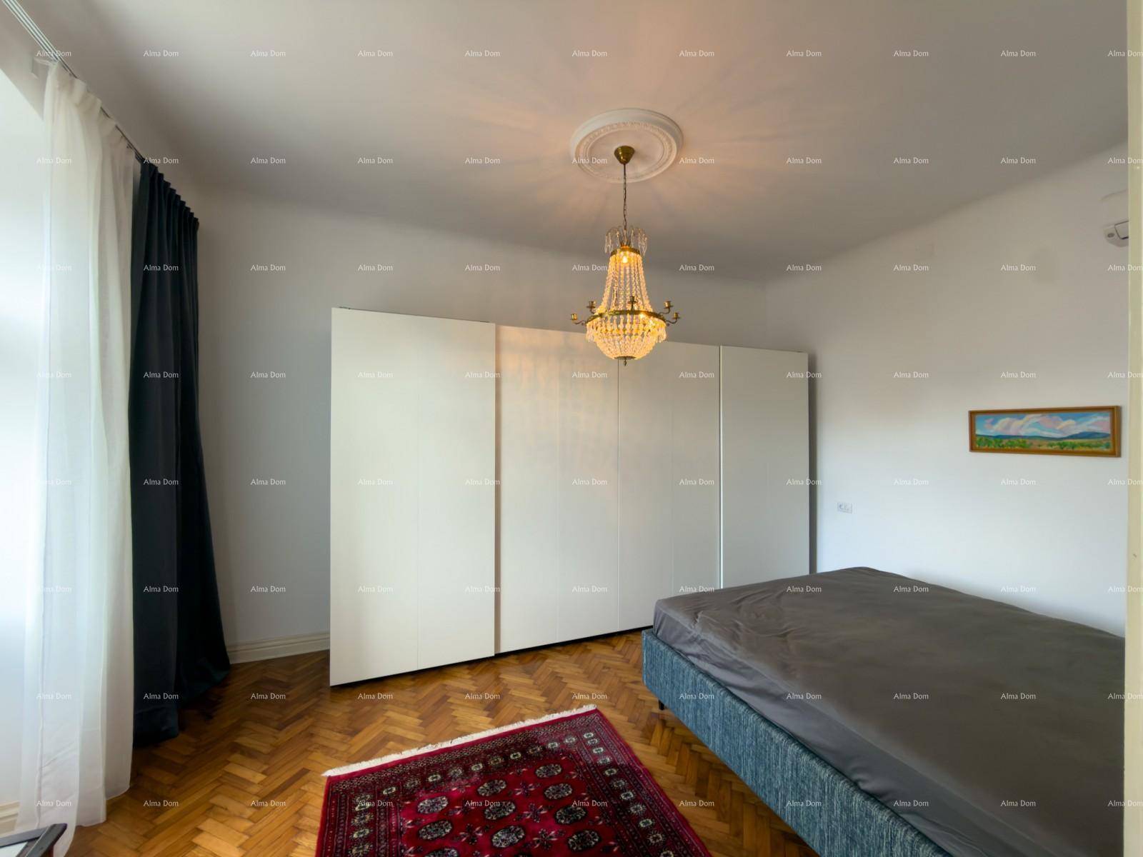 Geräumiges Schlafzimmer mit großem Bett, eleganten Einbauschränken und klassischem Fischgrätparkett.