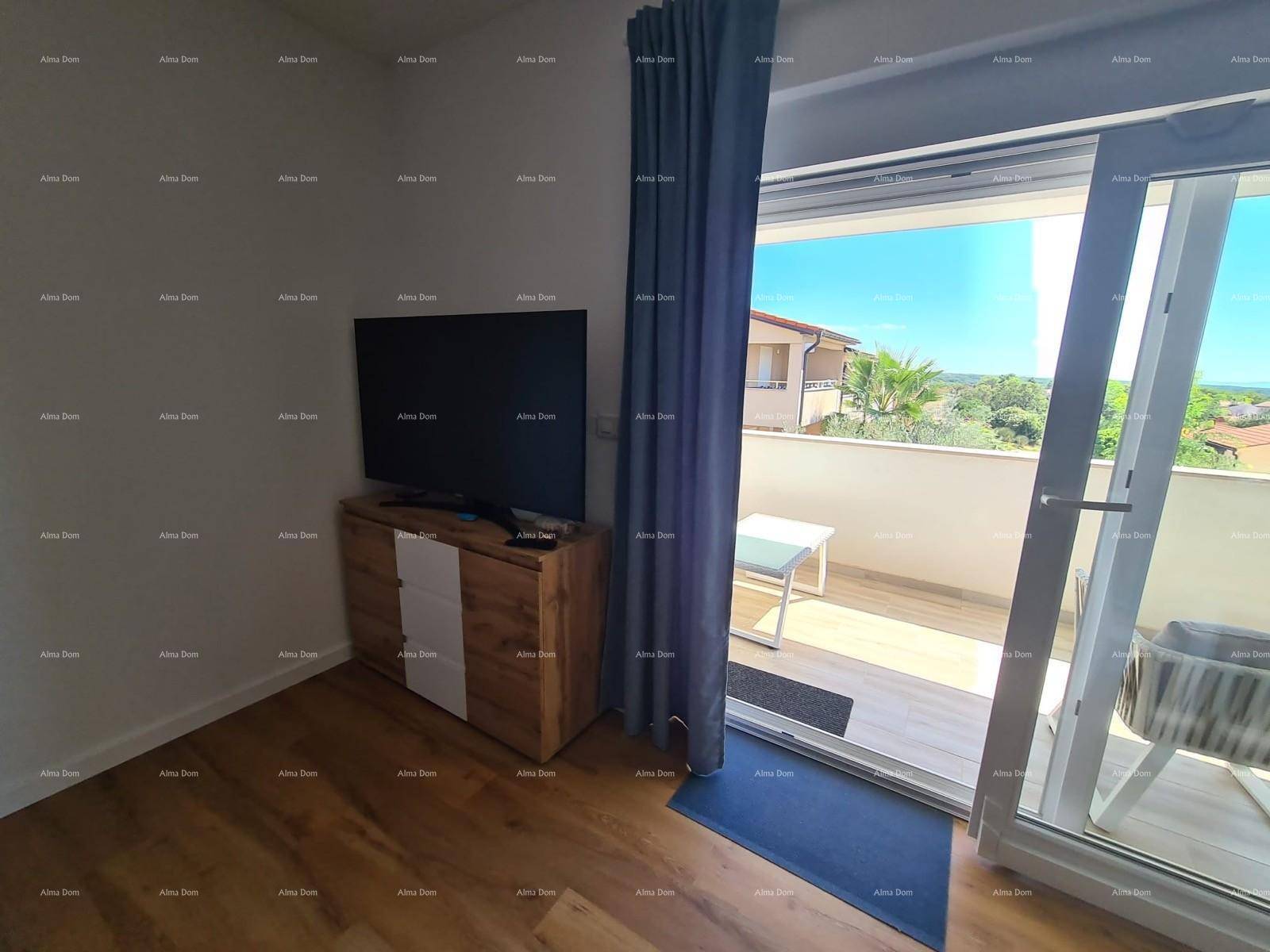 Detailansicht des Wohnzimmers mit Fernseher und großem Schiebetürzugang zum sonnigen Balkon.