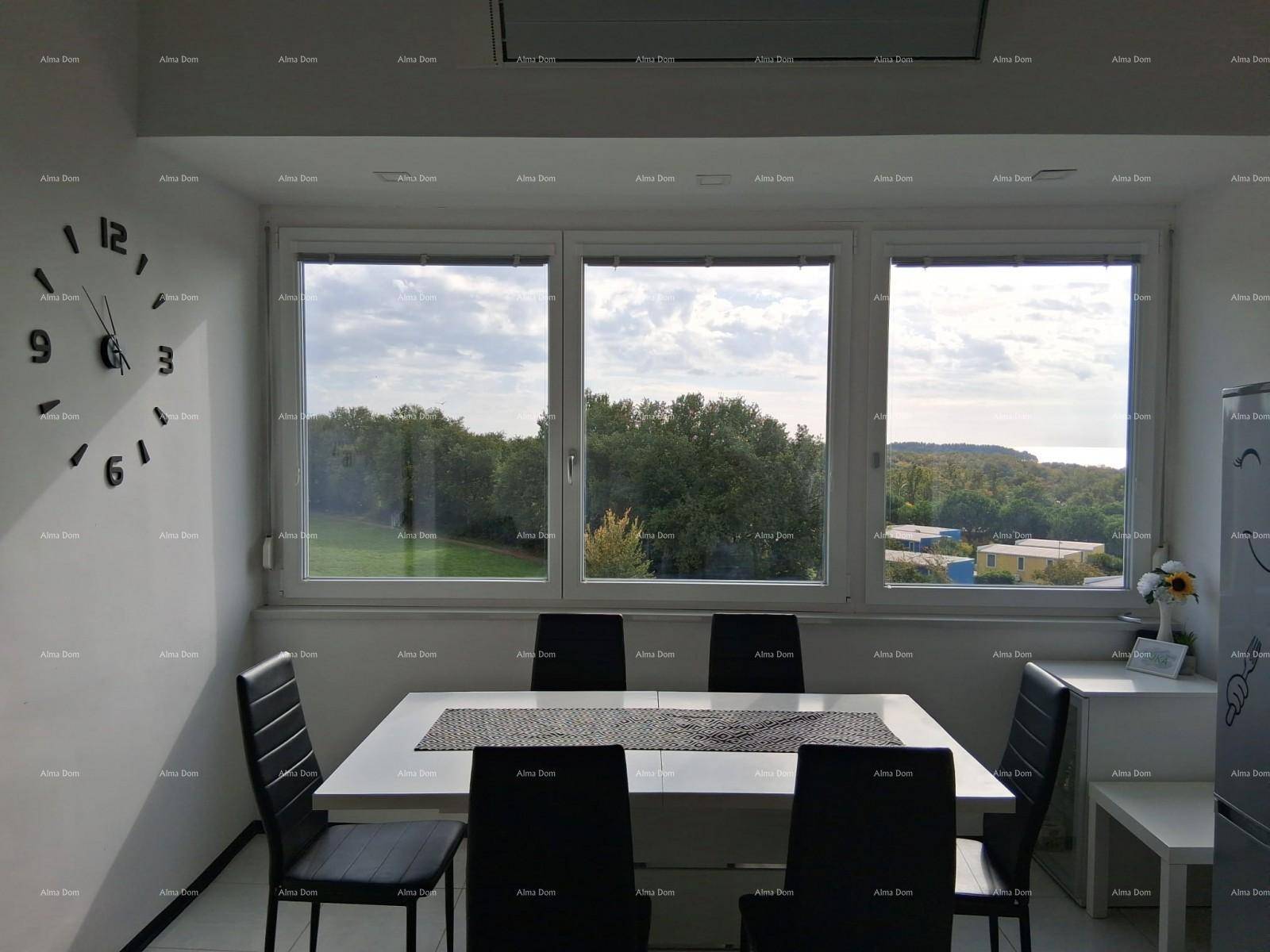Essbereich mit modernem Tisch und Stühlen, großen Fenstern und weitem Blick ins Grüne.