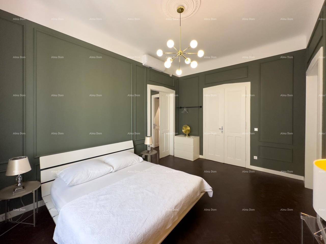 Geräumiges Schlafzimmer mit dunklem Parkettboden, grünen Wandpaneelen und einem modernen Doppelbett.