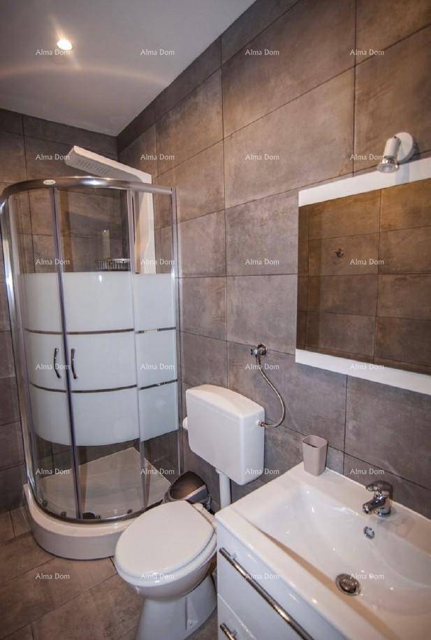 Funktionales Badezimmer mit Duschkabine, Toilette und Waschbecken mit Unterschrank.