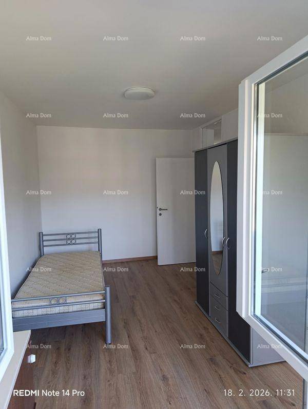 Schlafzimmer mit Einzelbett, Kleiderschrank und Laminatboden, mit Zugang zum Balkon.