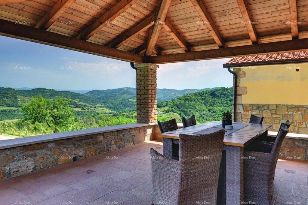 Große überdachte Terrasse mit Esstisch und Rattanmöbeln, ideal für Mahlzeiten im Freien mit Panoramablick.