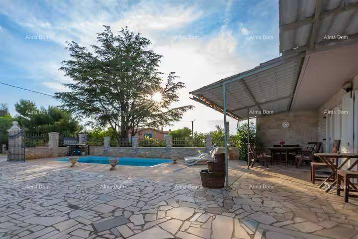 Überdachte Terrasse mit Essbereich im Freien und Blick auf den Poolbereich.