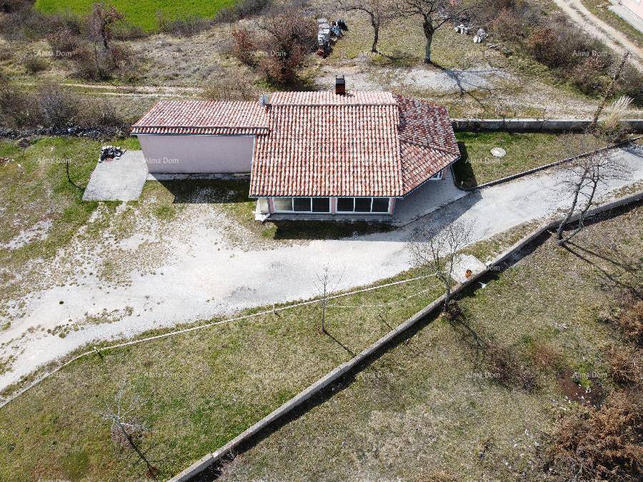 Nahaufnahme aus der Luft eines Hauses mit rotem Ziegeldach und umliegendem Grundstück.