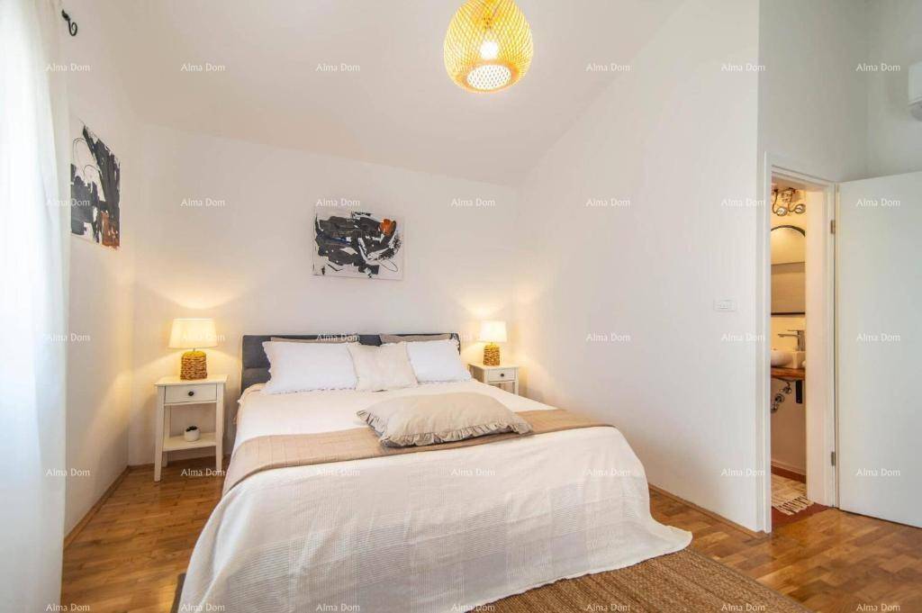 Helles Schlafzimmer mit Doppelbett, Nachttischen und Zugang zu einem angrenzenden Badezimmer.