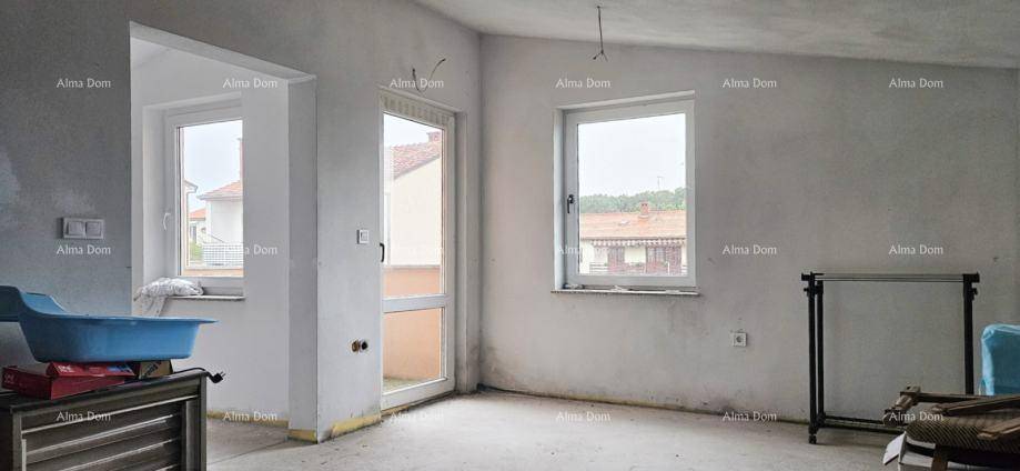 Heller, unfertiger Raum mit zwei Fenstern und Zugang zu einem Außenbereich, bereit für den Ausbau.