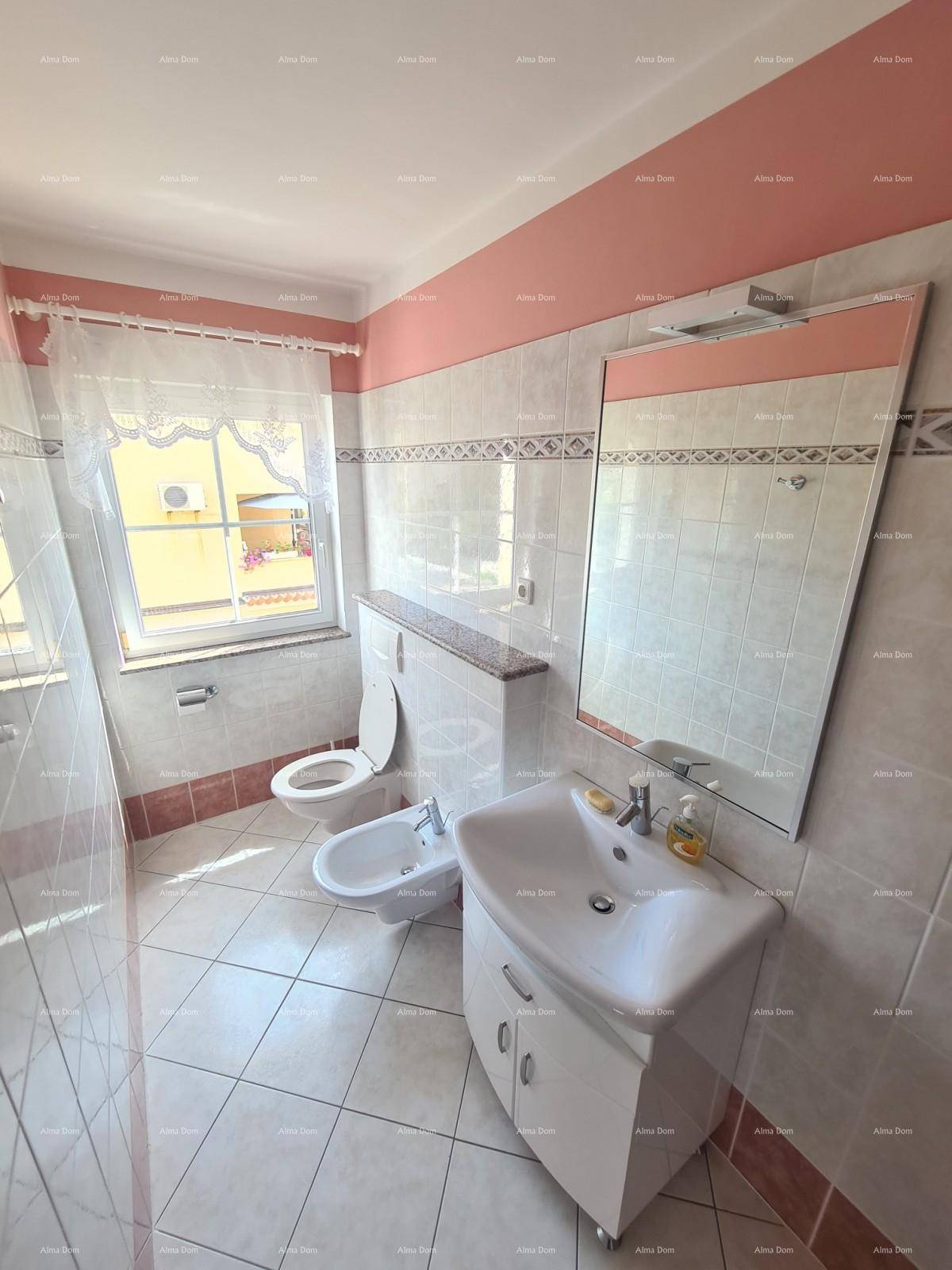 Badezimmer mit WC, Bidet, Waschbecken und Fenster.