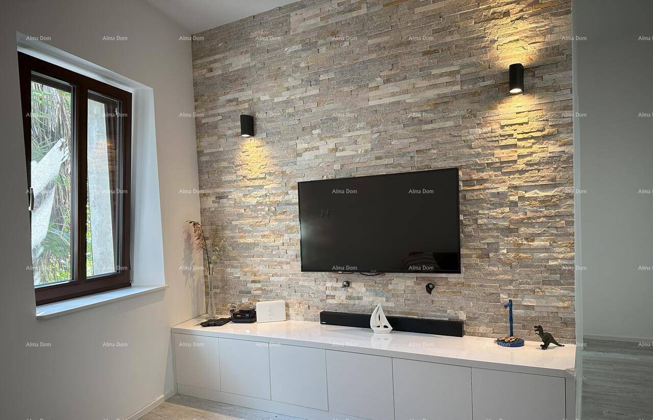 Wohnbereich mit Wandfernseher und einer stilvollen Steinwand als Akzent.