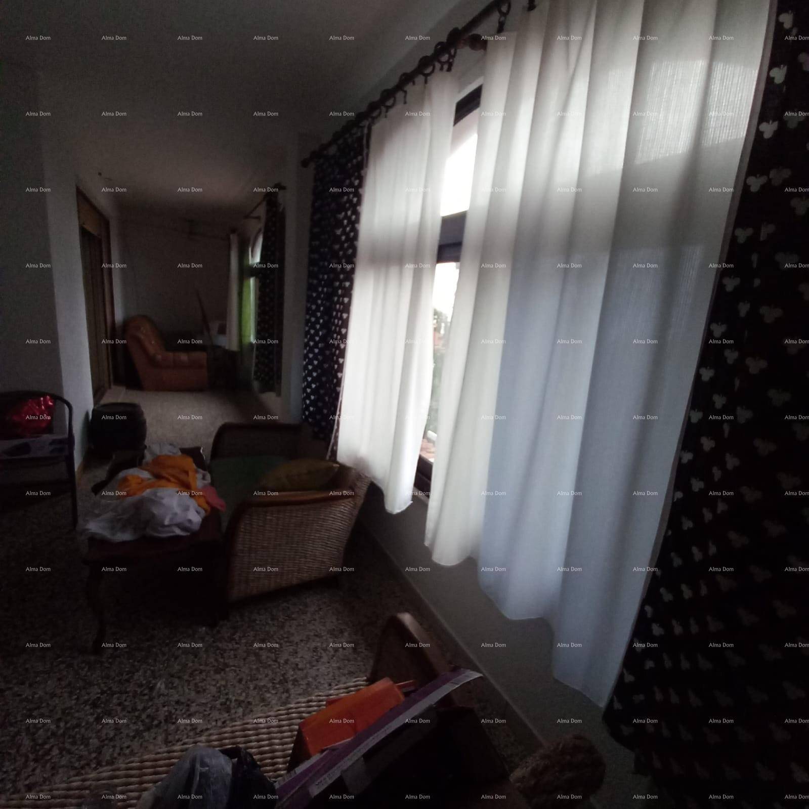 Langer Flur mit Teppichboden, Vorhängen und Blick in weitere Räume.