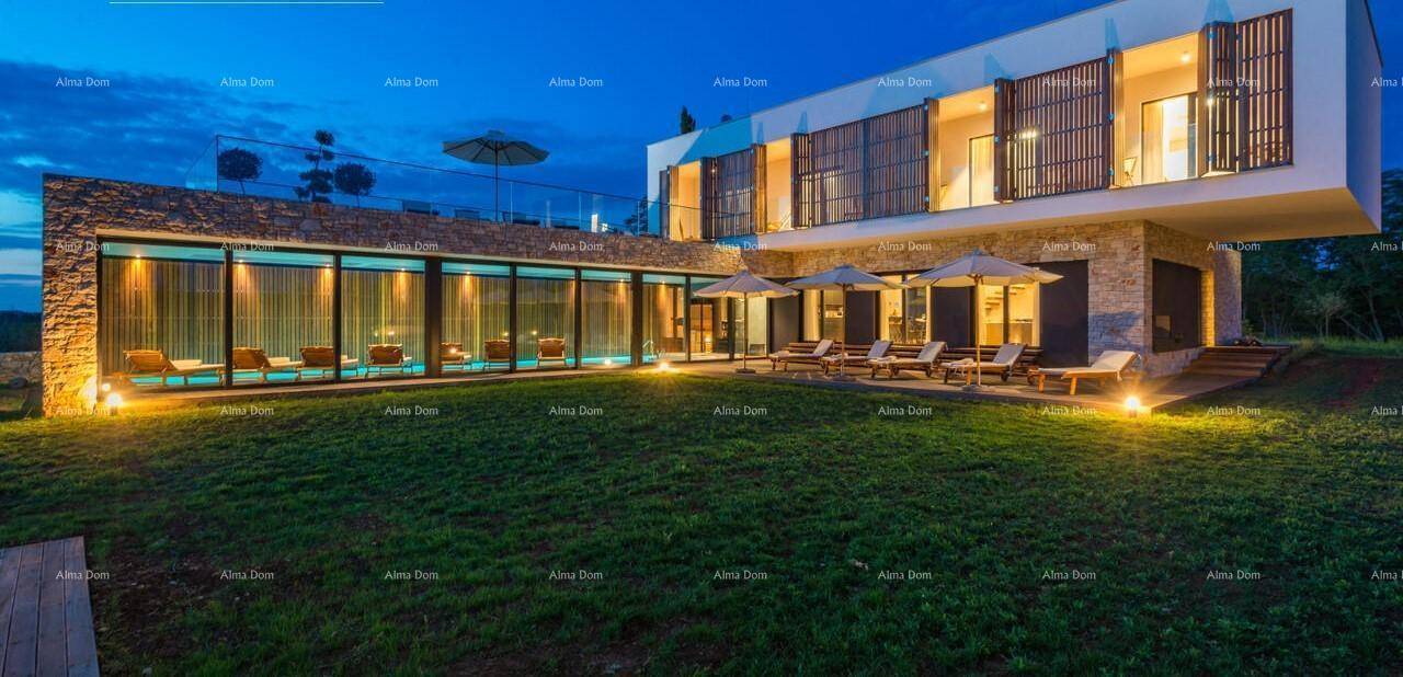 Beeindruckende moderne Villa bei Nacht, umgeben von einem weitläufigen Rasen und beleuchteten Terrassenbereichen.