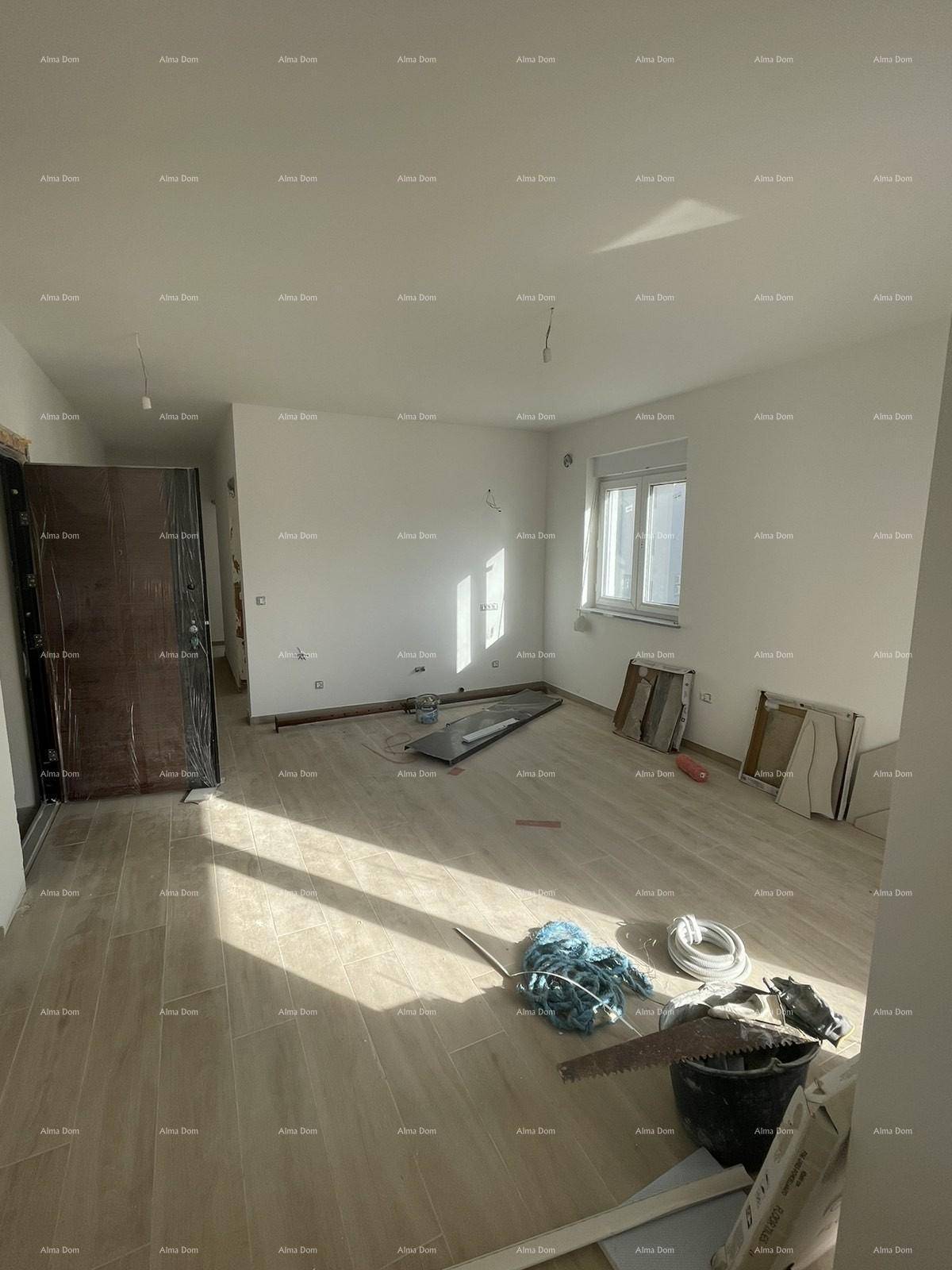 Geräumiges Wohnzimmer im Bau mit hellen Fliesen, viel Tageslicht und Blick auf den Eingangsbereich.