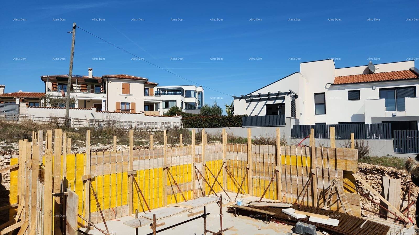 Baustelle mit vorbereitetem Fundament und Schalung für die Wände des Neubaus.