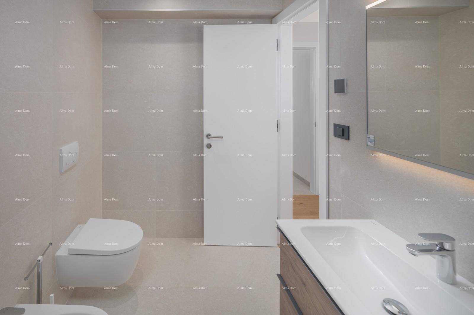 Elegantes Badezimmer mit Wand-WC, modernem Waschtisch und großem beleuchteten Spiegel.