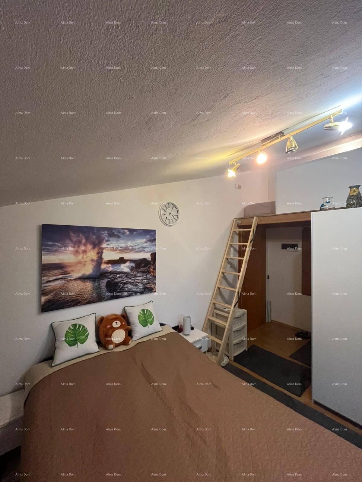 Schlafzimmer mit Doppelbett, Wandbild und einer Holzleiter, die zu einem erhöhten Schlafbereich führt.