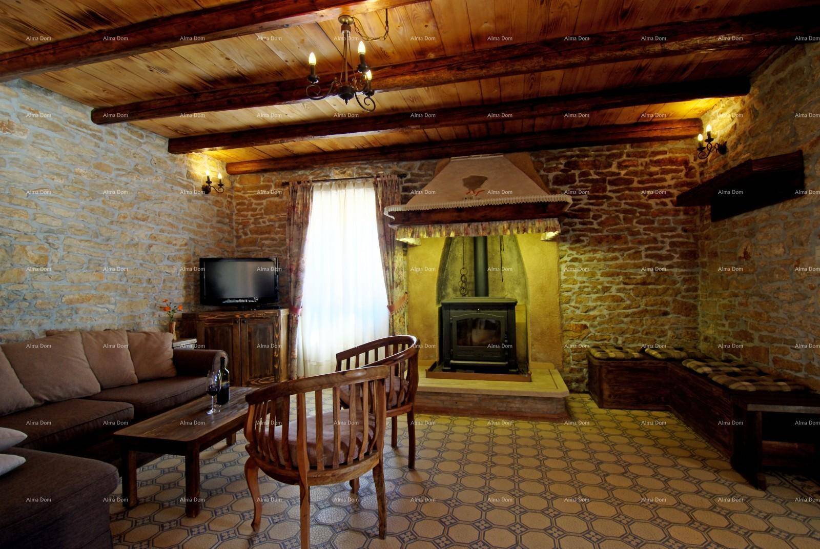 Rustikales Wohnzimmer mit Steinwänden, Holzbalkendecke und einem gemütlichen Holzofen als Mittelpunkt.