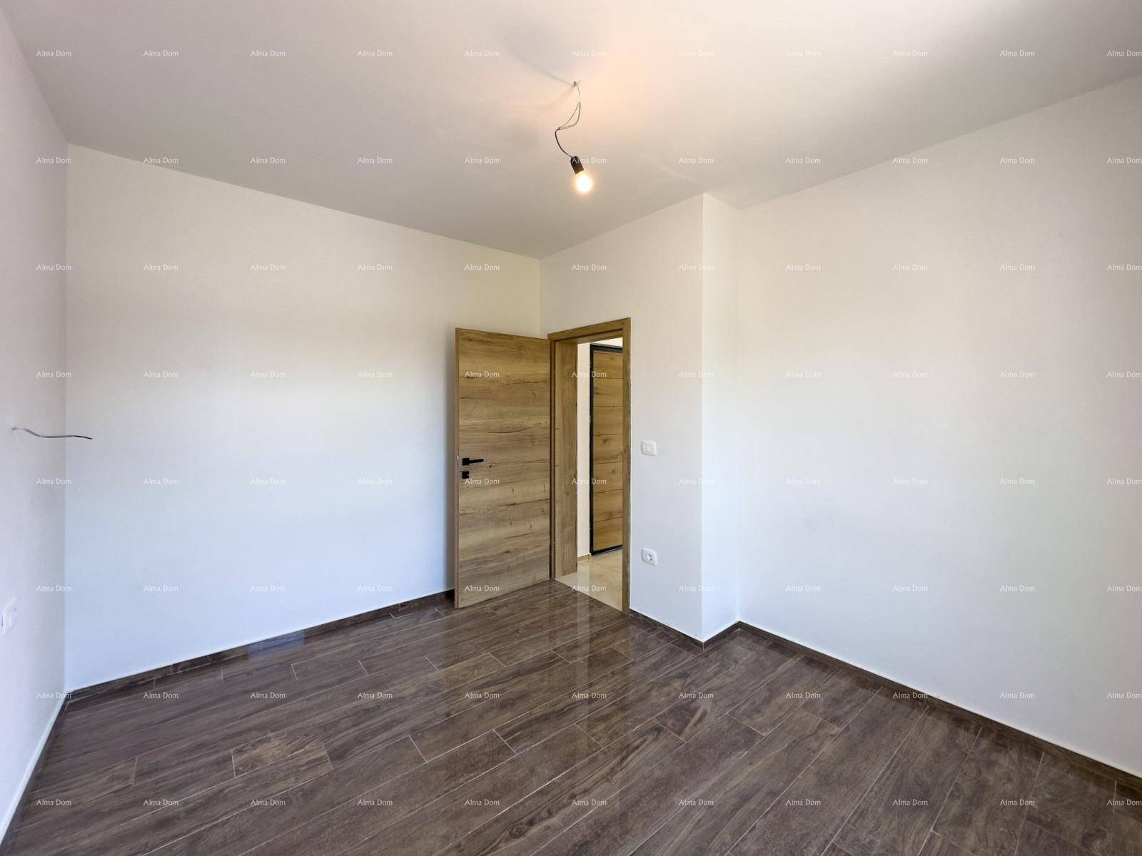 Modernes Schlafzimmer mit dunklem Fliesenboden und einer Holztür, die zu einem weiteren Raum führt.