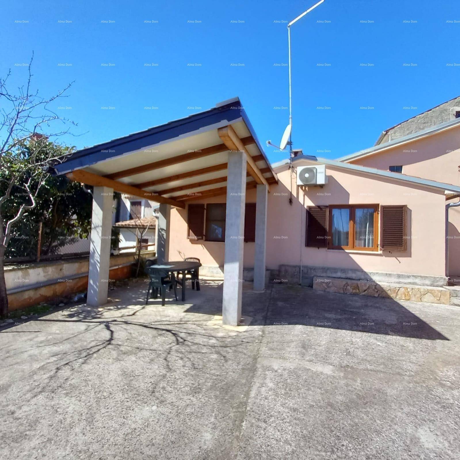 Überdachte Terrasse mit Sitzgelegenheiten und einem Carport neben dem Wohnhaus.