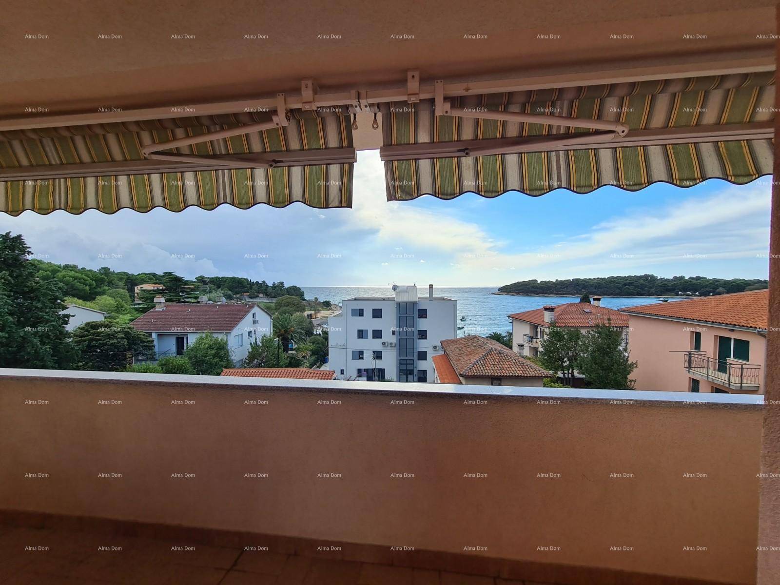 Balkon mit Markise und weitem Blick auf das Meer und die Küstenlandschaft.