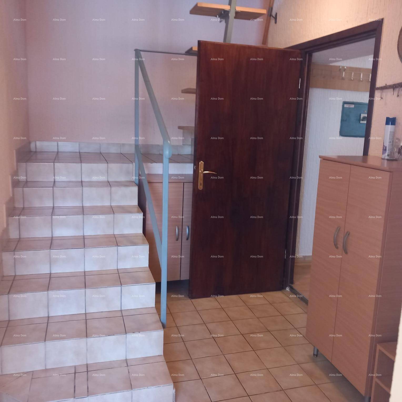Eingangsbereich mit gefliester Treppe, die in die oberen Stockwerke führt.