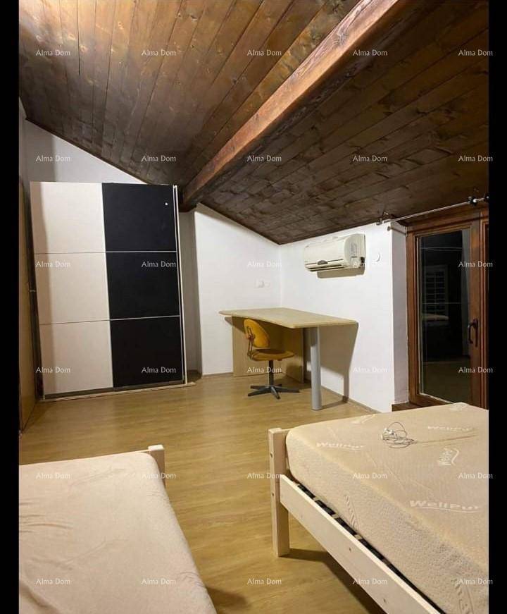 Schlafzimmer im Dachgeschoss mit Holzbalkendecke, zwei Betten und Klimaanlage.
