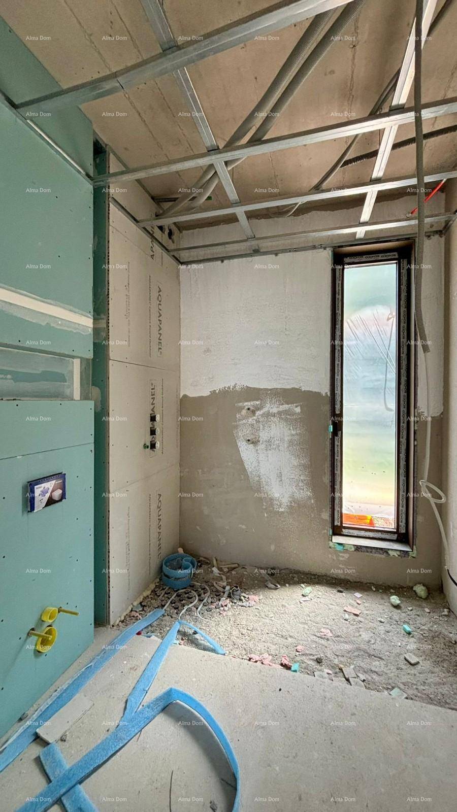 Badezimmer im Rohbau mit vorbereiteten Installationen und einem schmalen Fenster.
