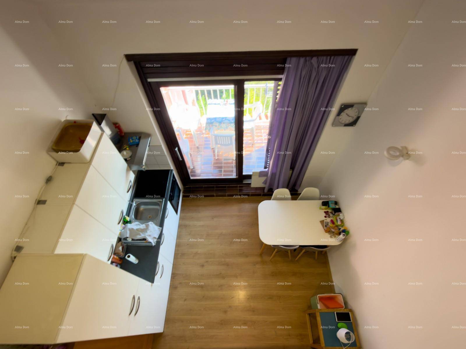 Draufsicht auf die Küchenzeile und den Essbereich mit Zugang zum Balkon.