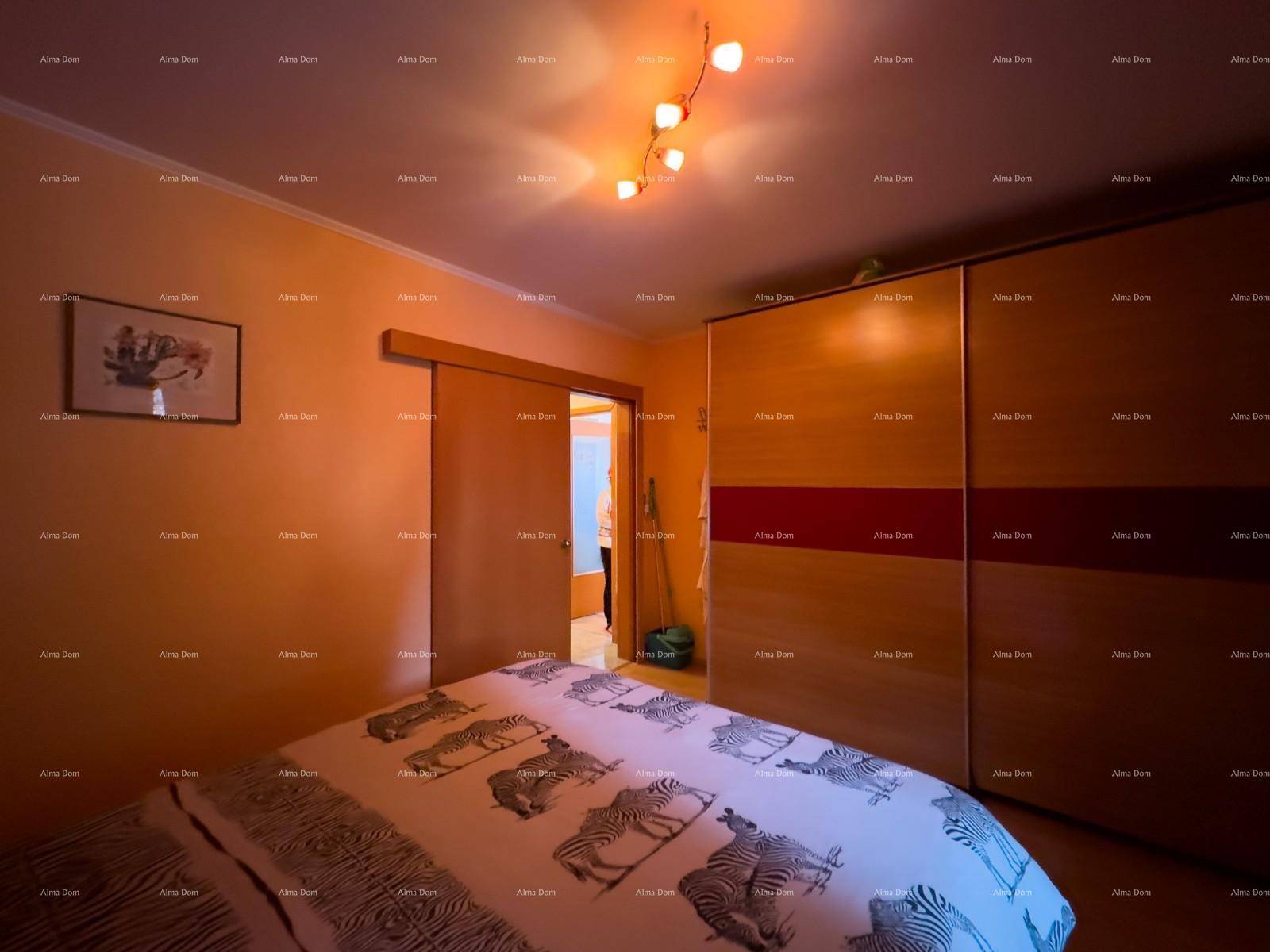 Schlafzimmer mit Doppelbett, großem Kleiderschrank und Schiebetür.
