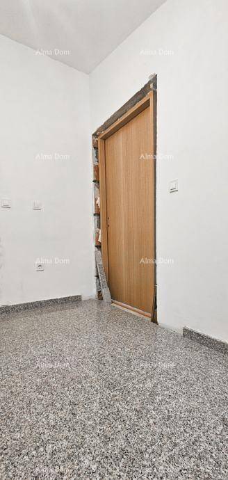 Unfertiger Raum mit Holztürrahmen und gesprenkeltem Fliesenboden, bereit für den Ausbau.