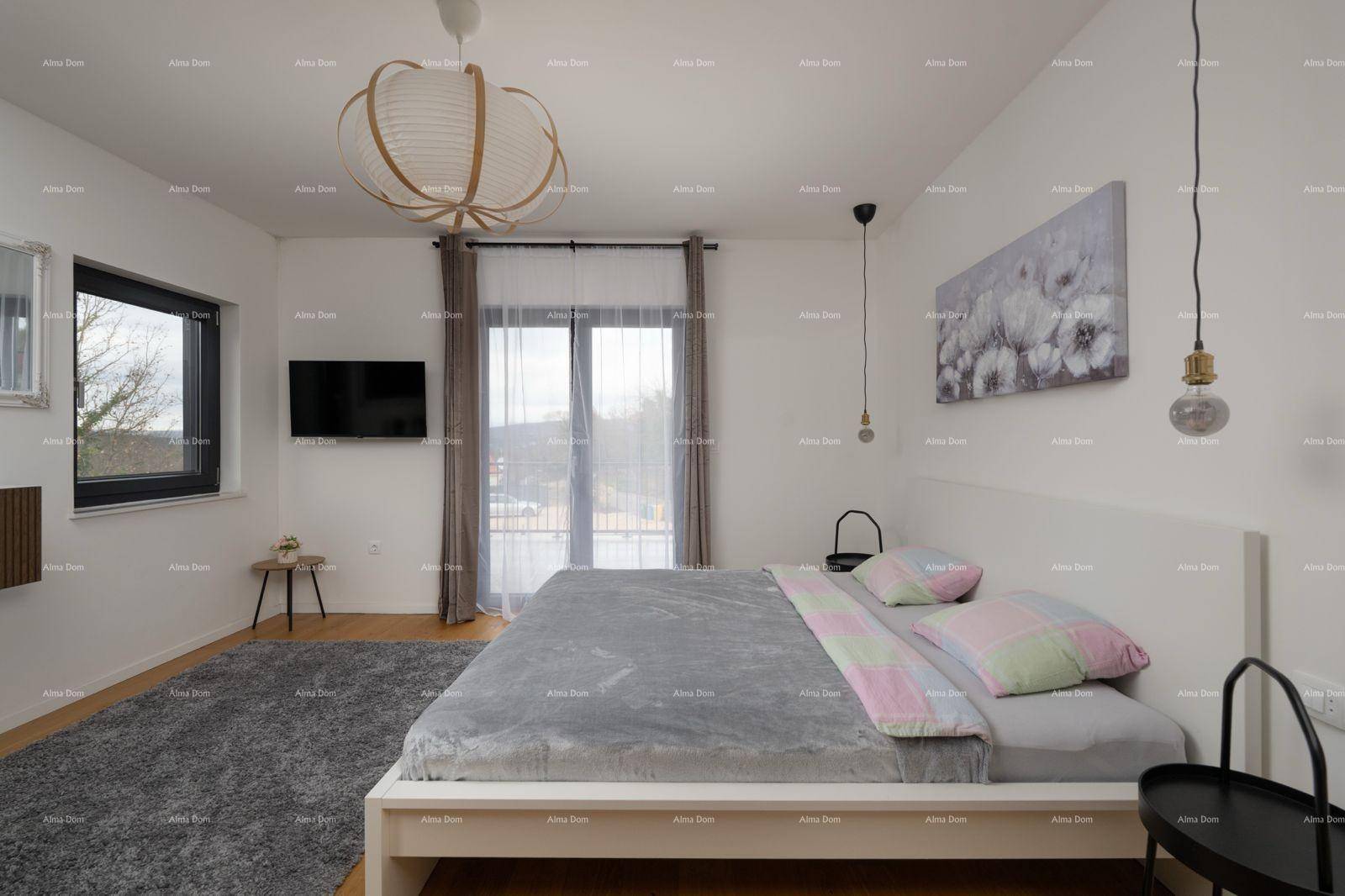 Helles Schlafzimmer mit Doppelbett, Holzboden und Zugang zu einem Balkon.