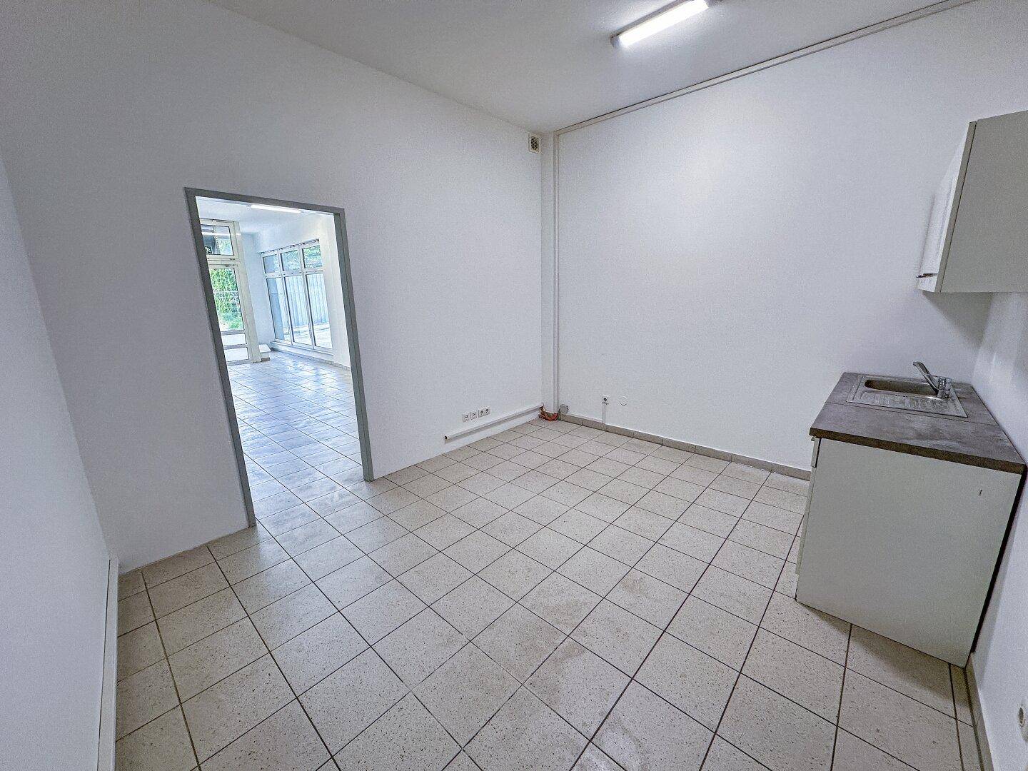 Kleiner Raum mit Fliesenboden und einer einfachen Küchenzeile mit Spüle und Hängeschrank.
