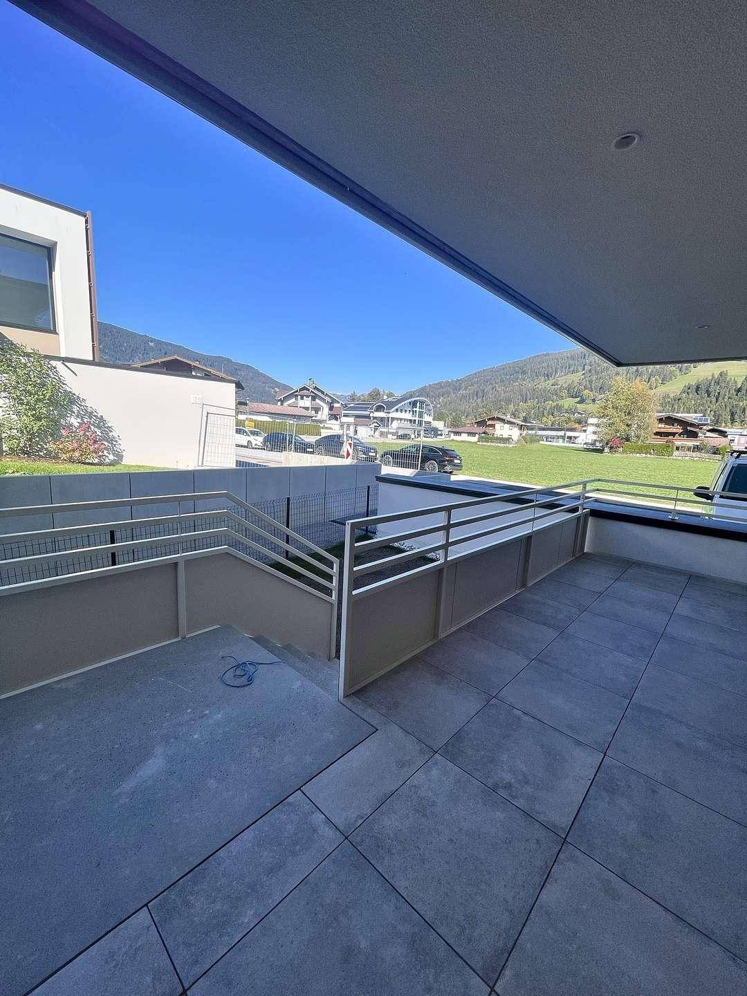 Geräumiger Balkon mit Treppenzugang und weitem Blick auf die Natur und Berge.