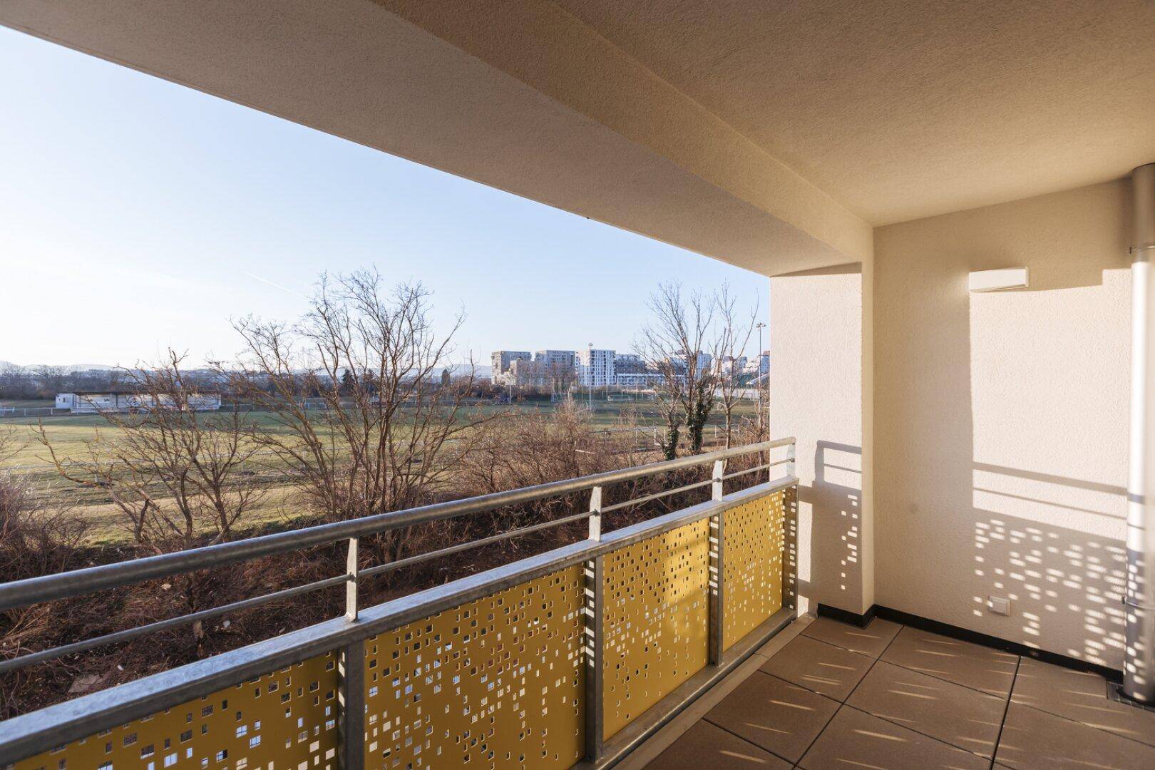 Geräumiger Balkon mit Blick auf eine Grünfläche und die umliegende Bebauung.