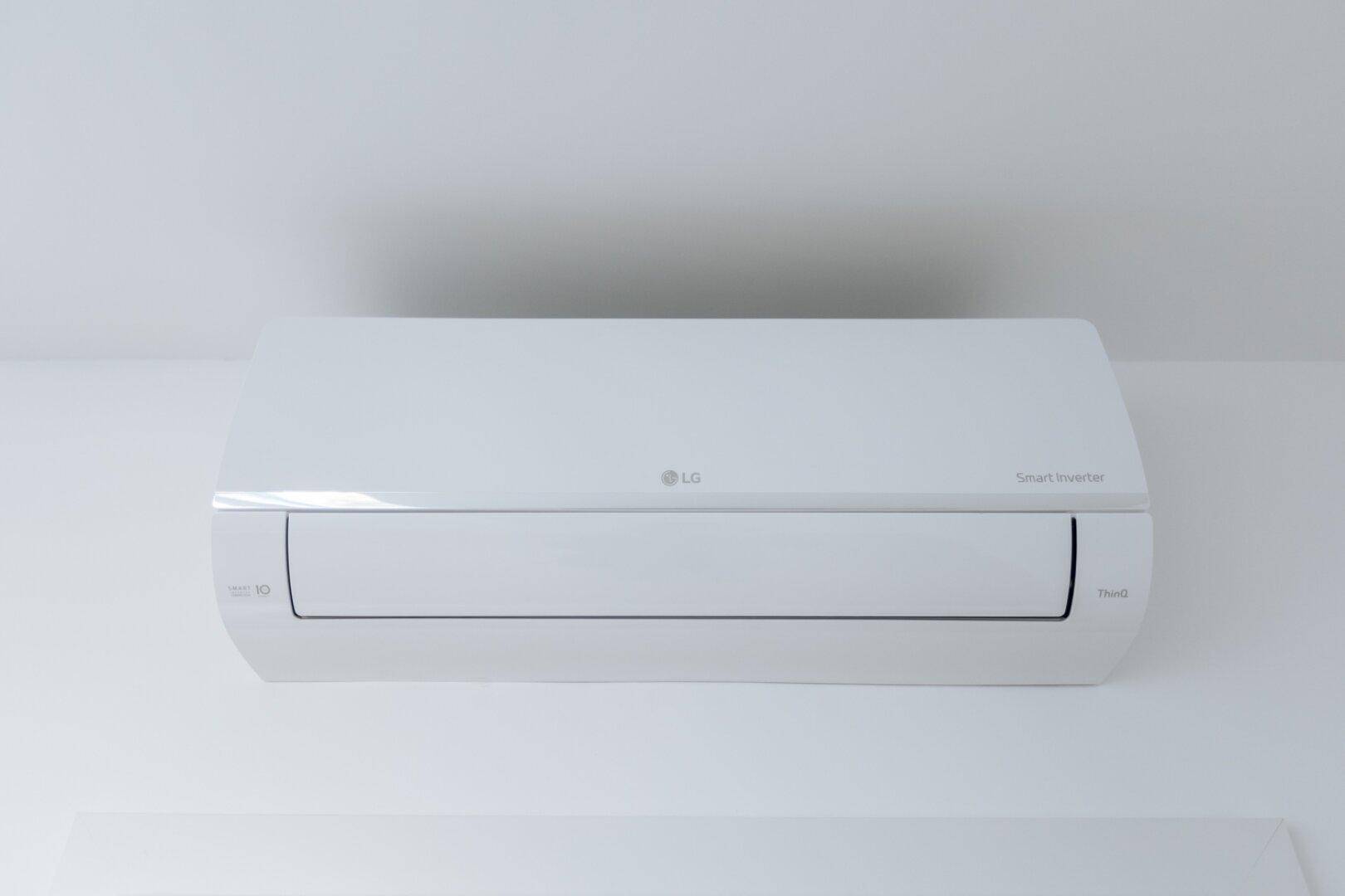 Nahaufnahme einer modernen LG Smart Inverter Klimaanlage an einer weißen Decke.
