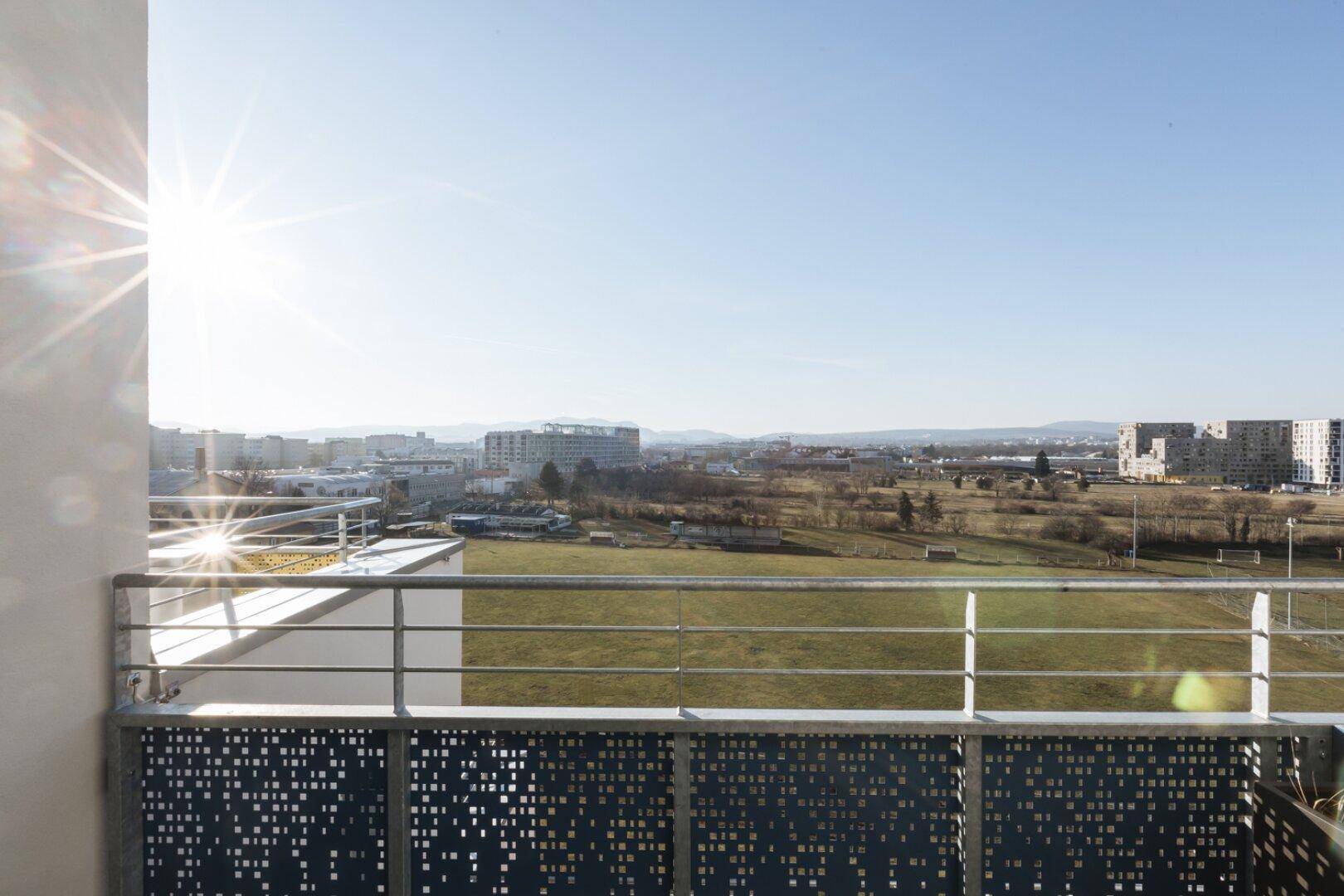 Sonniger Balkon mit weitem Blick über die Stadtlandschaft und die umliegende Natur.